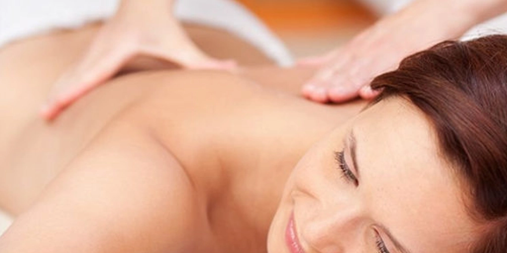 Mulher recebendo massagem corporal esfoliante com óleos essenciais