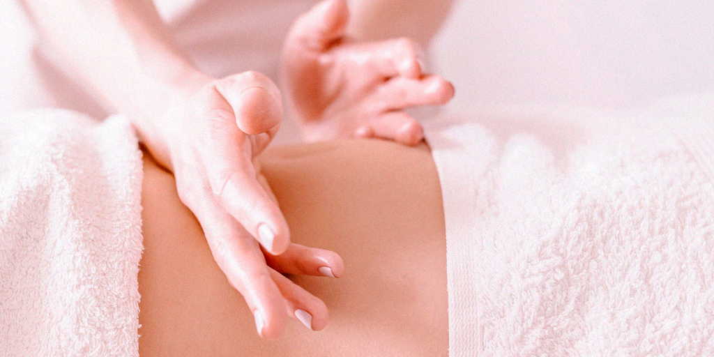 Mulher relaxando durante massagem tântrica no SPA com ambiente acolhedor e aromas terapêuticos